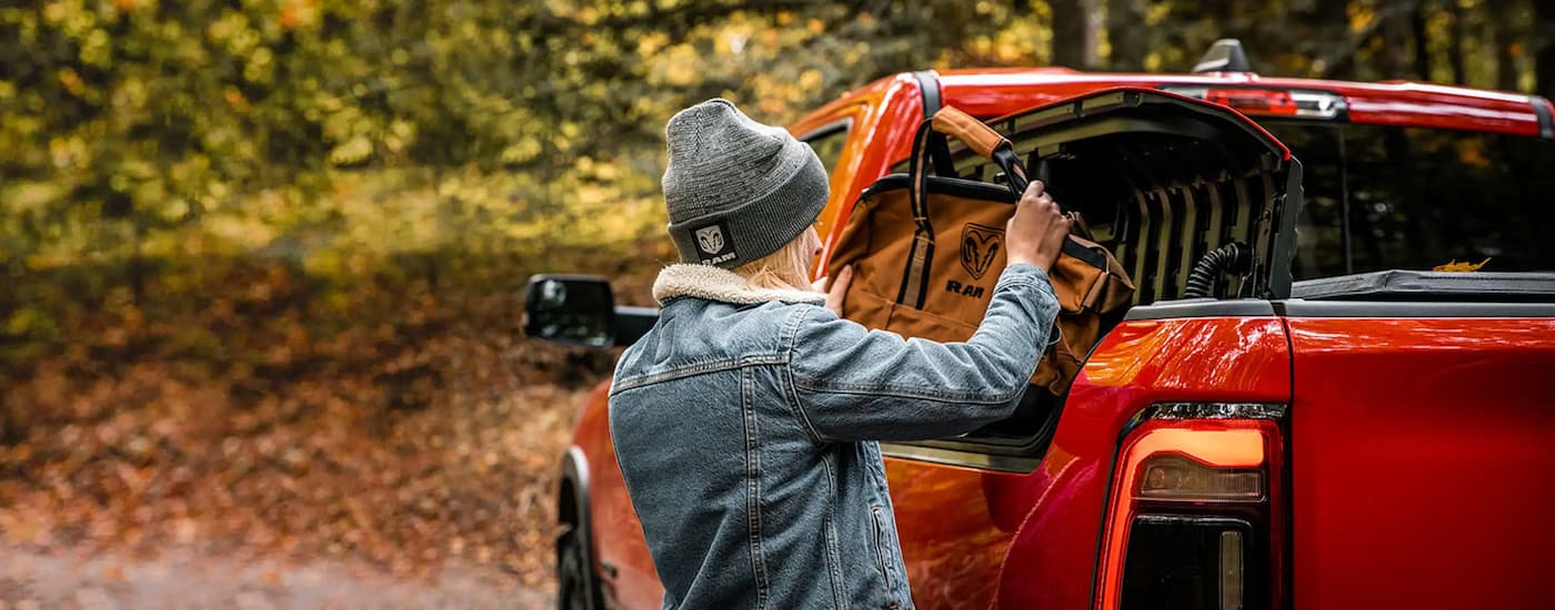 Woman using the Ram Box on a red 2023 Ram 1500.