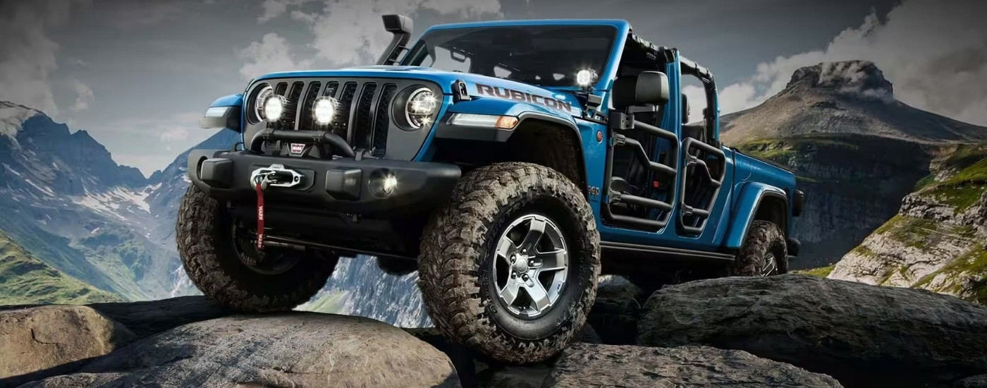 A blue 2020 Jeep Gladiator Rubicon is parked on rocks.