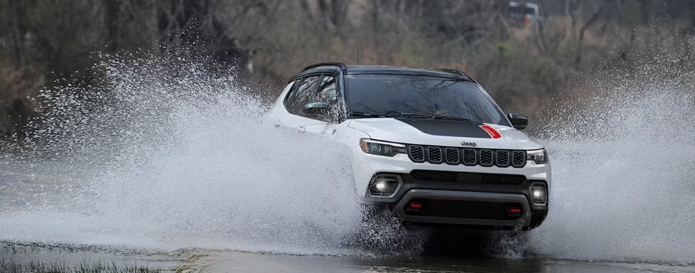 A white 2025 Jeep Compass for sale from the front.