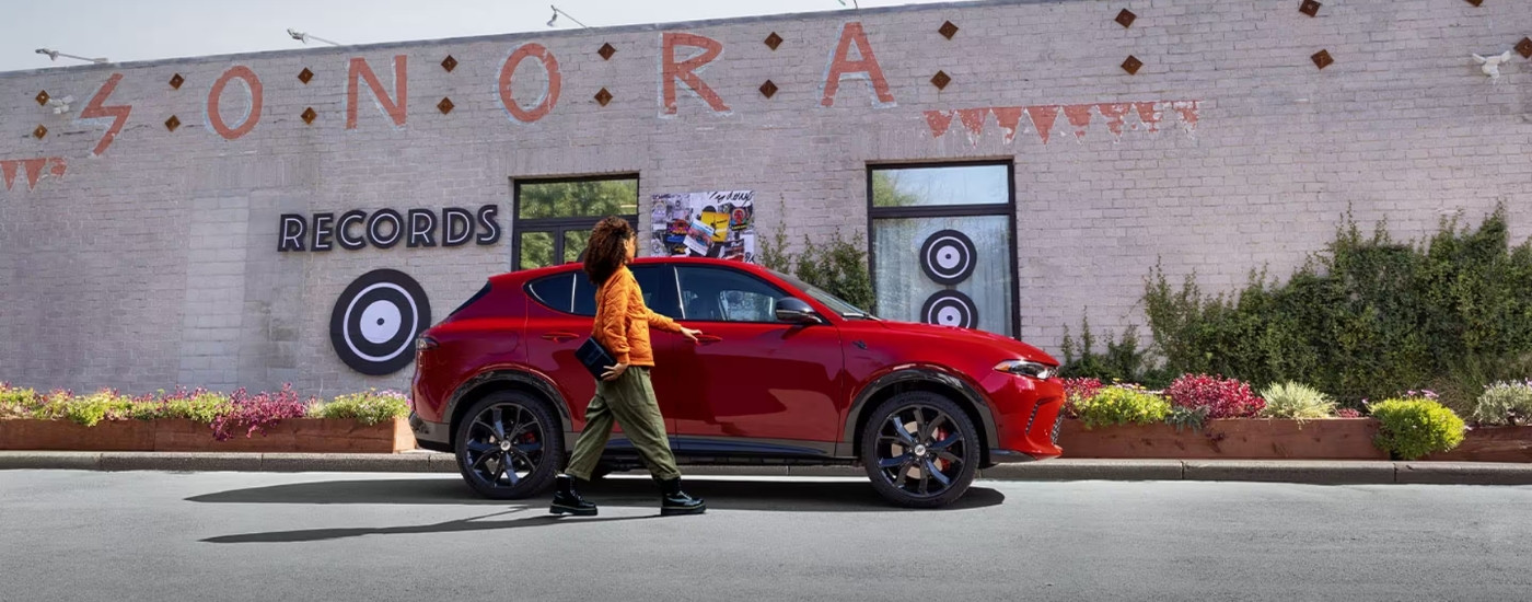 A red 2025 Dodge Hornet from the side after leaving a Dodge dealer near Tomball.