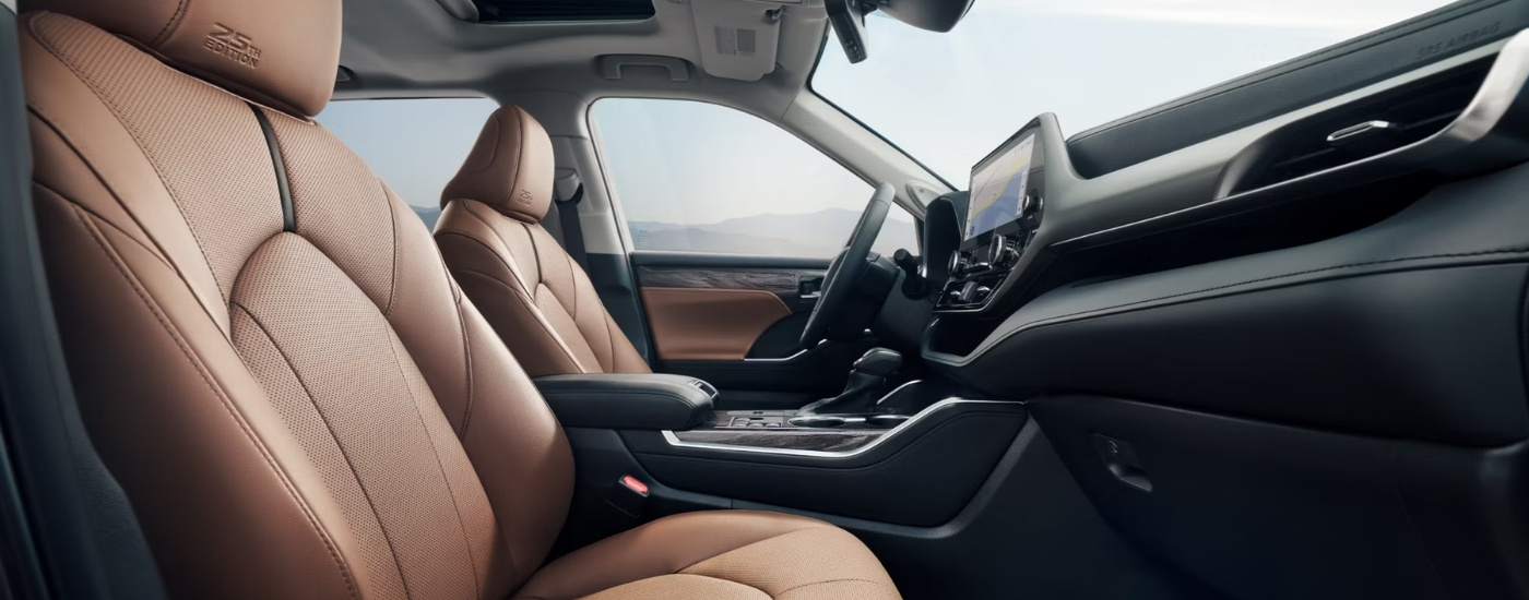 The brown interior of a 2025 Toyota Highlander from the passenger side.