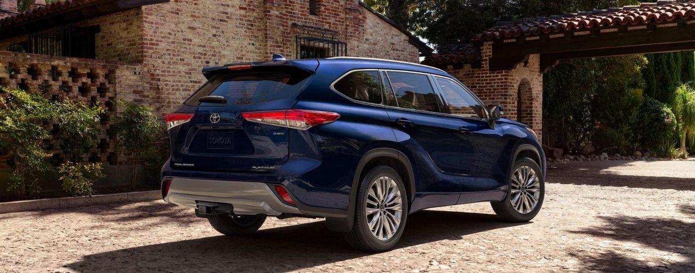 A blue 2025 Toyota Highlander from the rear at an angle.