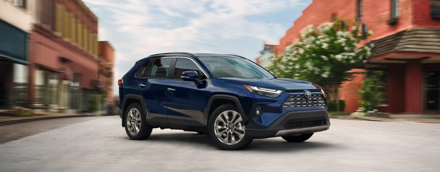 A blue 2025 Toyota RAV4 Hybrid for sale near Austin from the side.