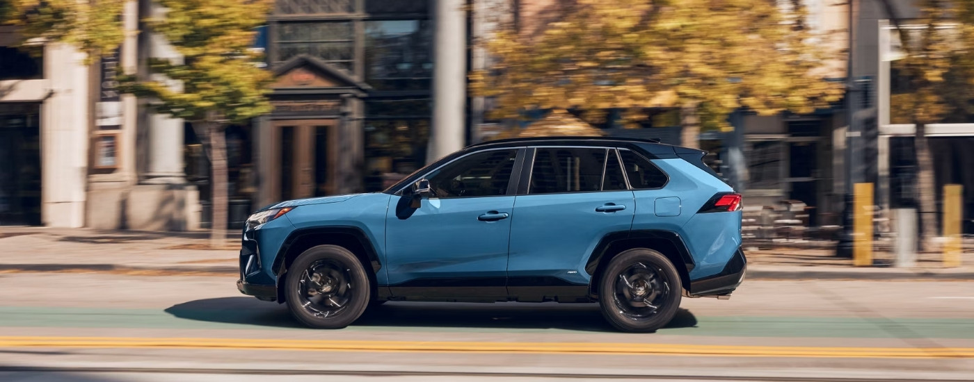 A blue 2025 Toyota RAV4 Hybrid from the side.