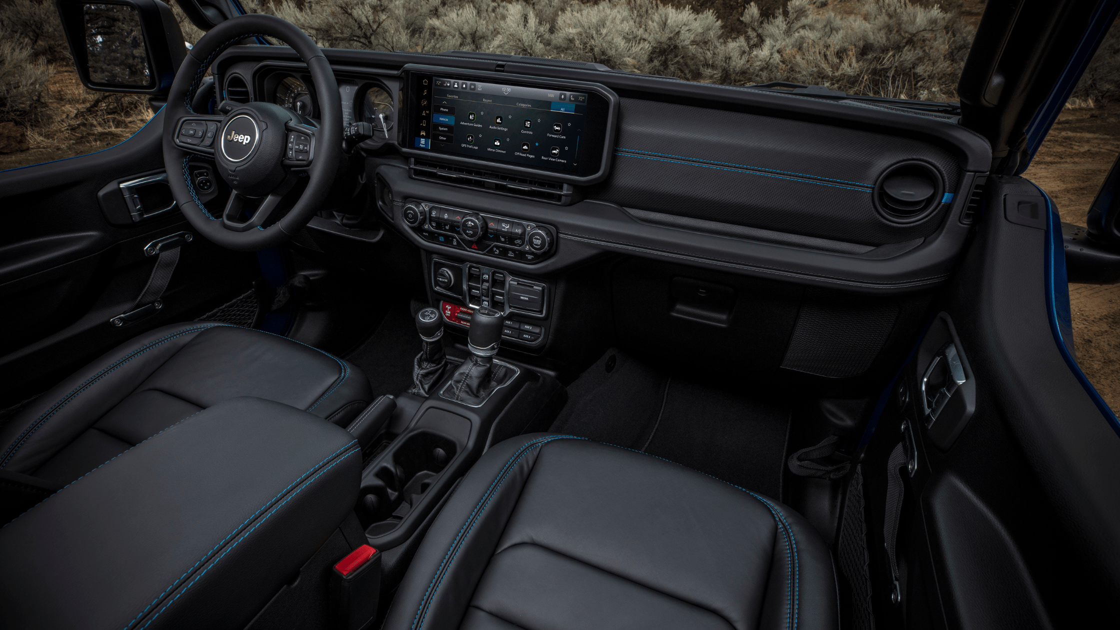 Interior view of the 2025 Jeep&reg; Wrangler 4xe showcasing black leather seats with blue stitching and a large center touchscreen.