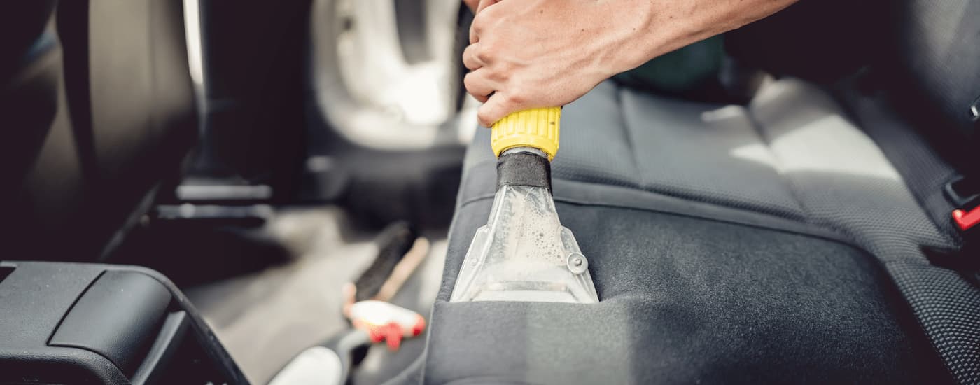 Rear car bench is being steam vacuumed.