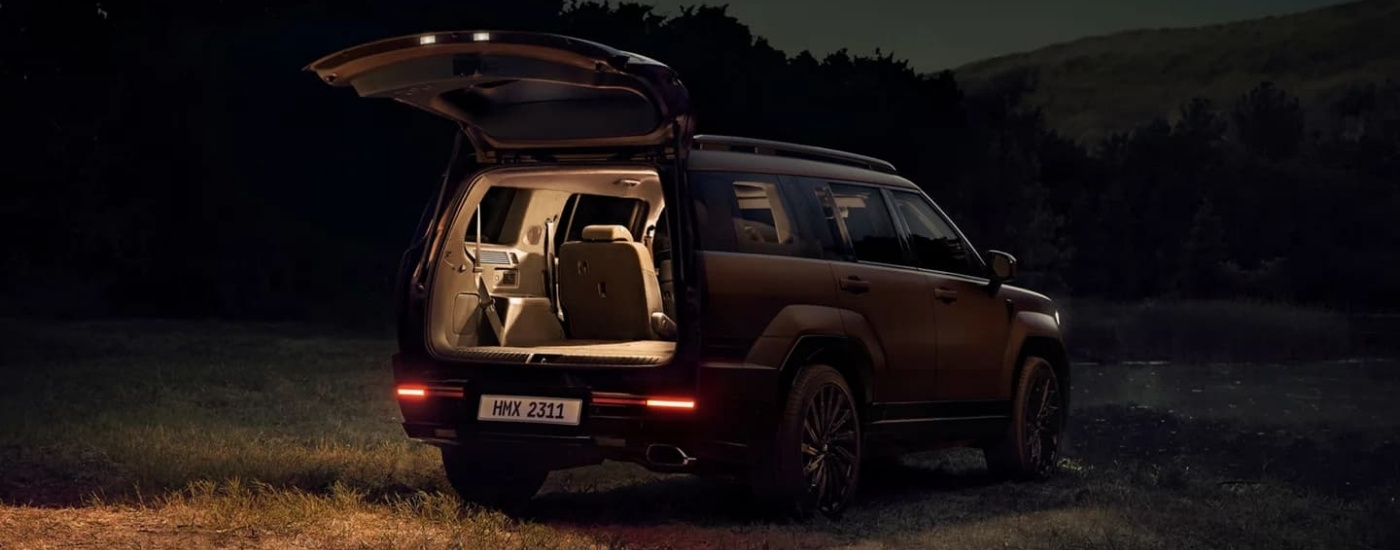 A bronze 2024 Hyundai Santa Fe parked on a field at night.