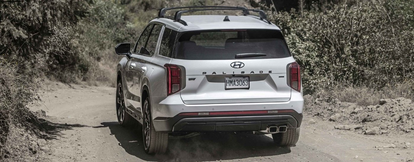 A white 2023 Hyundai Palisade driving on a dusty trail.