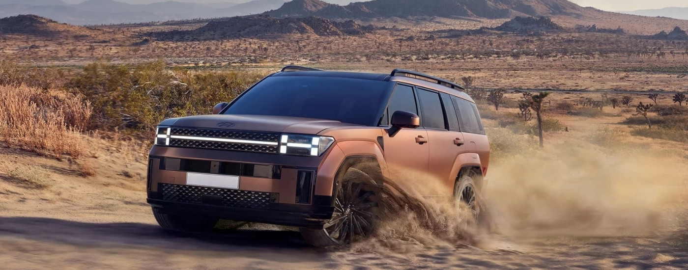 A bronze 2024 Hyundai Santa Fe for sale is off-roading.