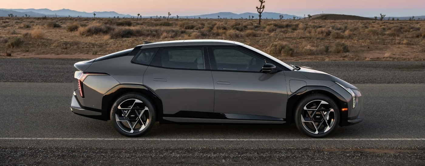 A grey 2026 Kia EV4 from the side after leaving a Kia dealer near Lincoln.