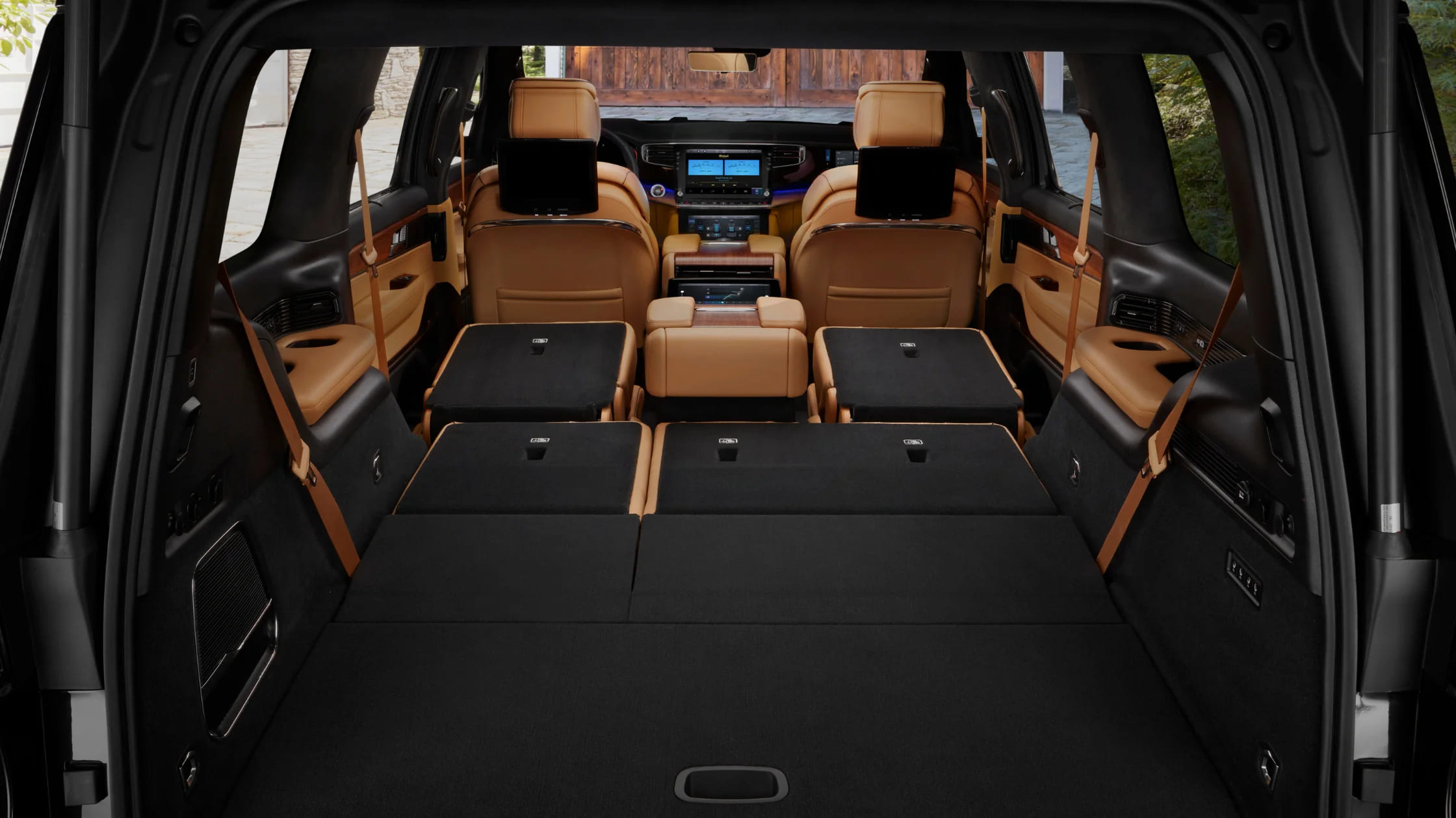 View of 2025 Jeep Grand Wagoneer interior from rear with seats folded flat, showcasing cargo space