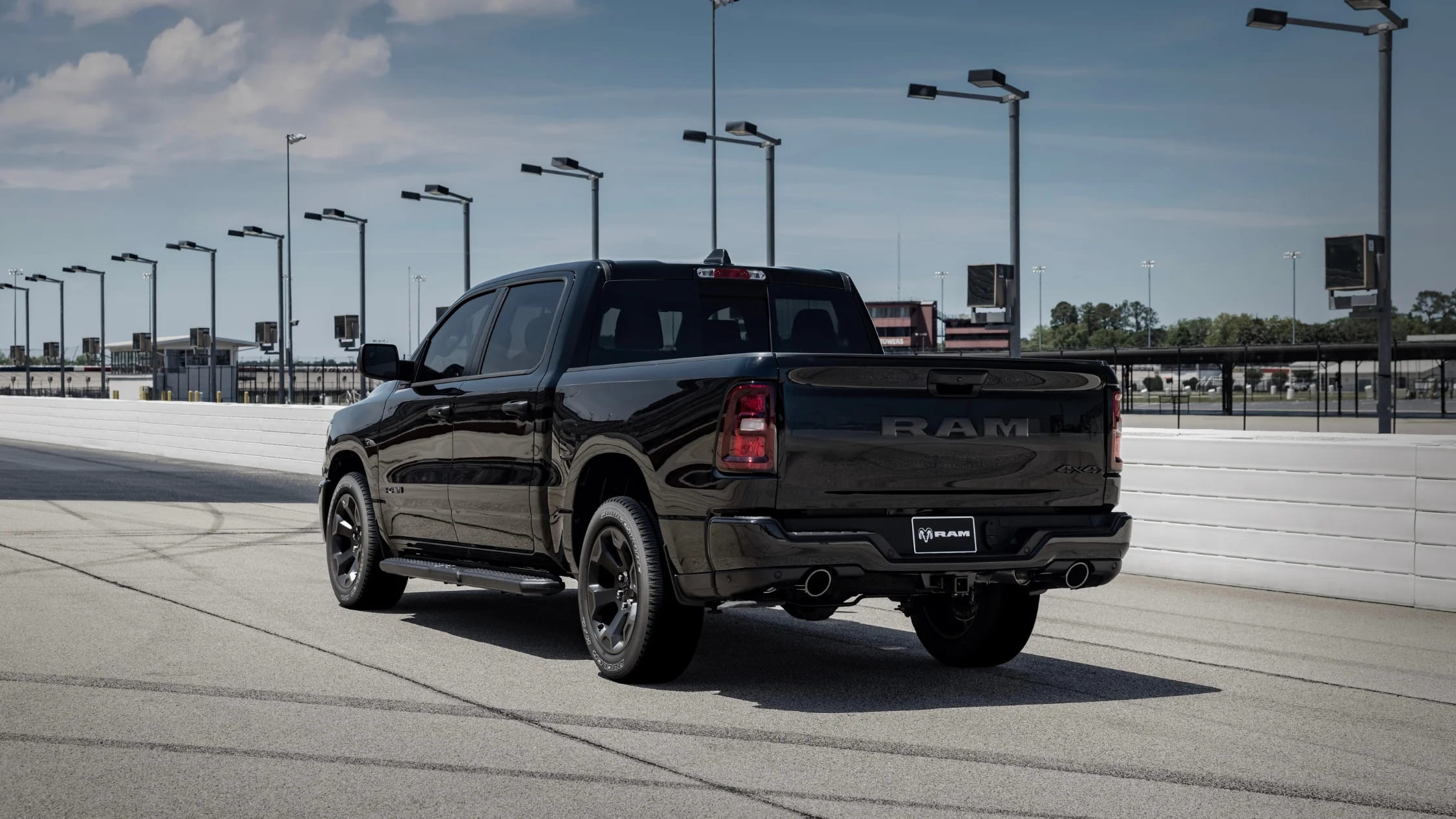 Rear view of the 2026 Ram 1500 Express showing dual exhaust and 4x4 badging on raceway pavement.