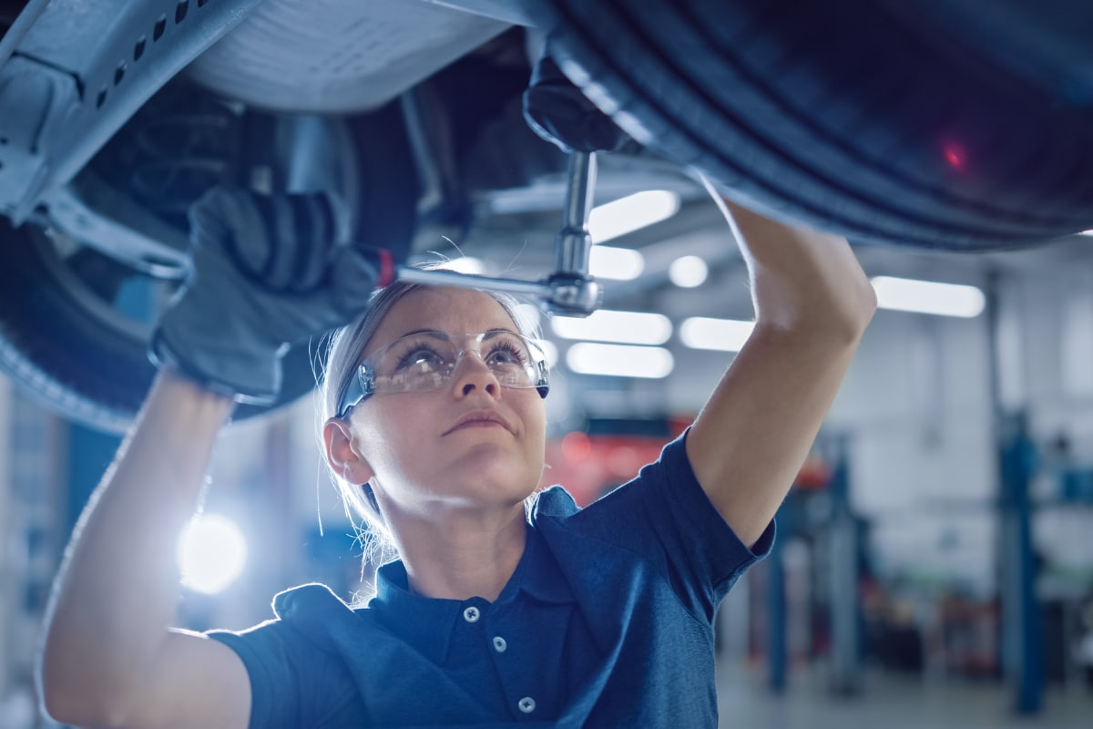 Mechanic working on the undercarriage of a vehicle