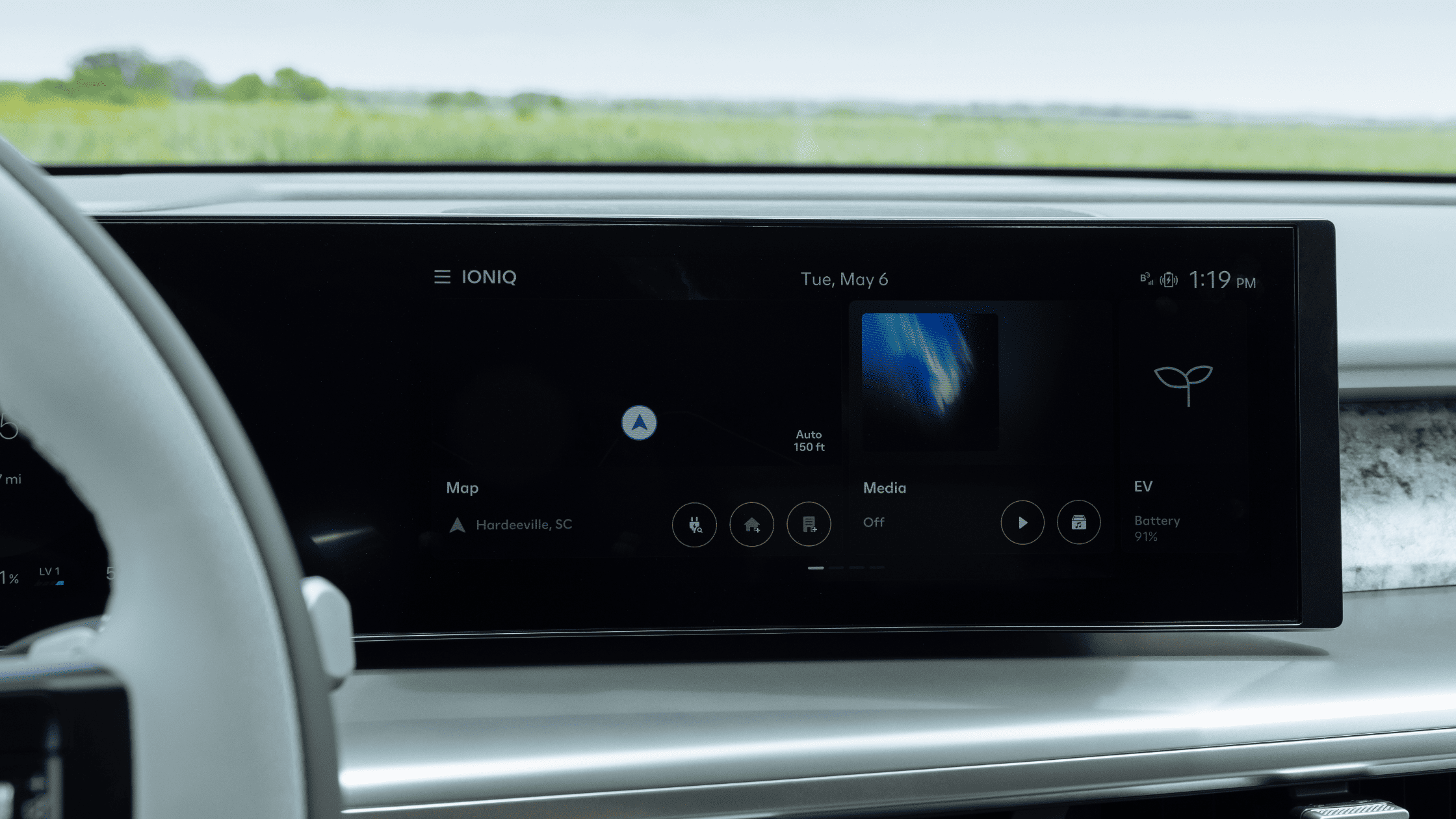 2026 Hyundai IONIQ 9 electric SUV driving on highway with palm trees and blue sky in background.