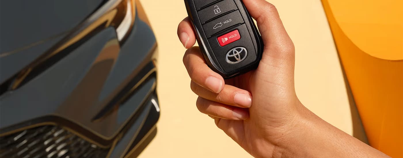 Keyfob in front of a grey 2025 Toyota Corolla.