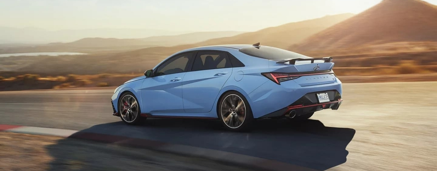 A blue 2022 Hyundai Elantra N driving on a racetrack.