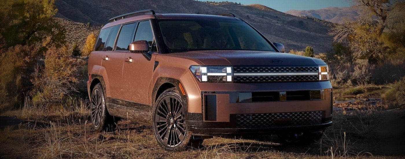 A brown 2025 Hyundai Santa Fe Hybrid parked off-road.