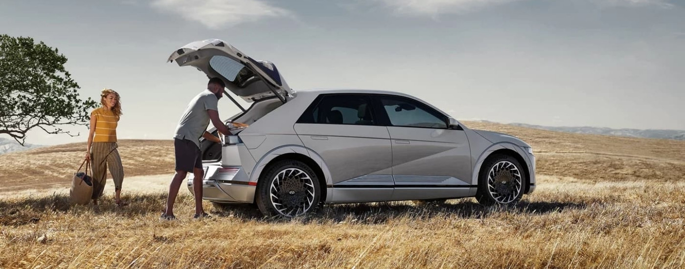 A silver 2023 Hyundai IONIQ 5 parked on a field.