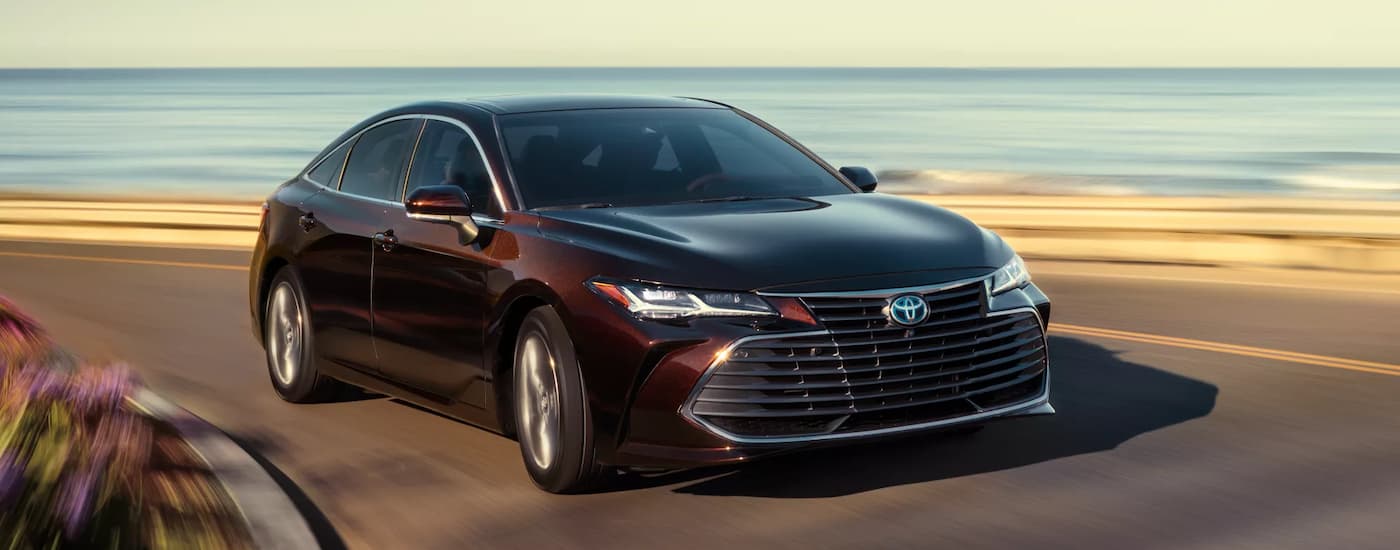 Brown 2022 Toyota Avalon driving on a winding road