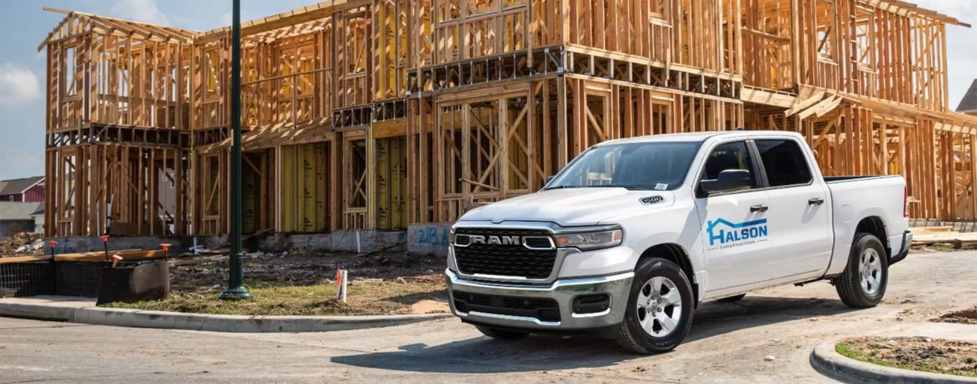A white 2025 Ram 1500 from the side.