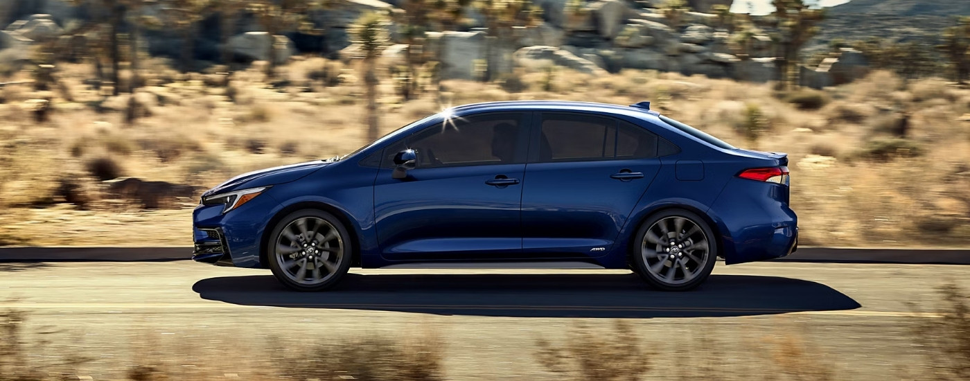 A blue 2023 Toyota Corolla from the side after leaving a used car dealer near Austin.