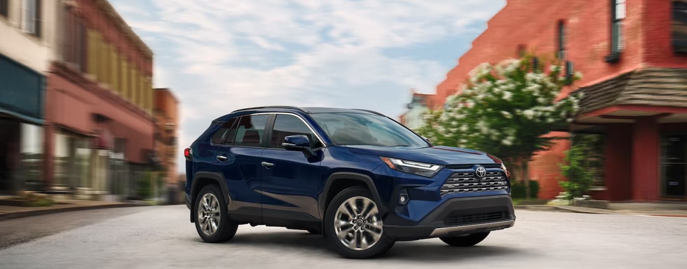 Blue 2025 Toyota RAV4 Hybrid driving through a city