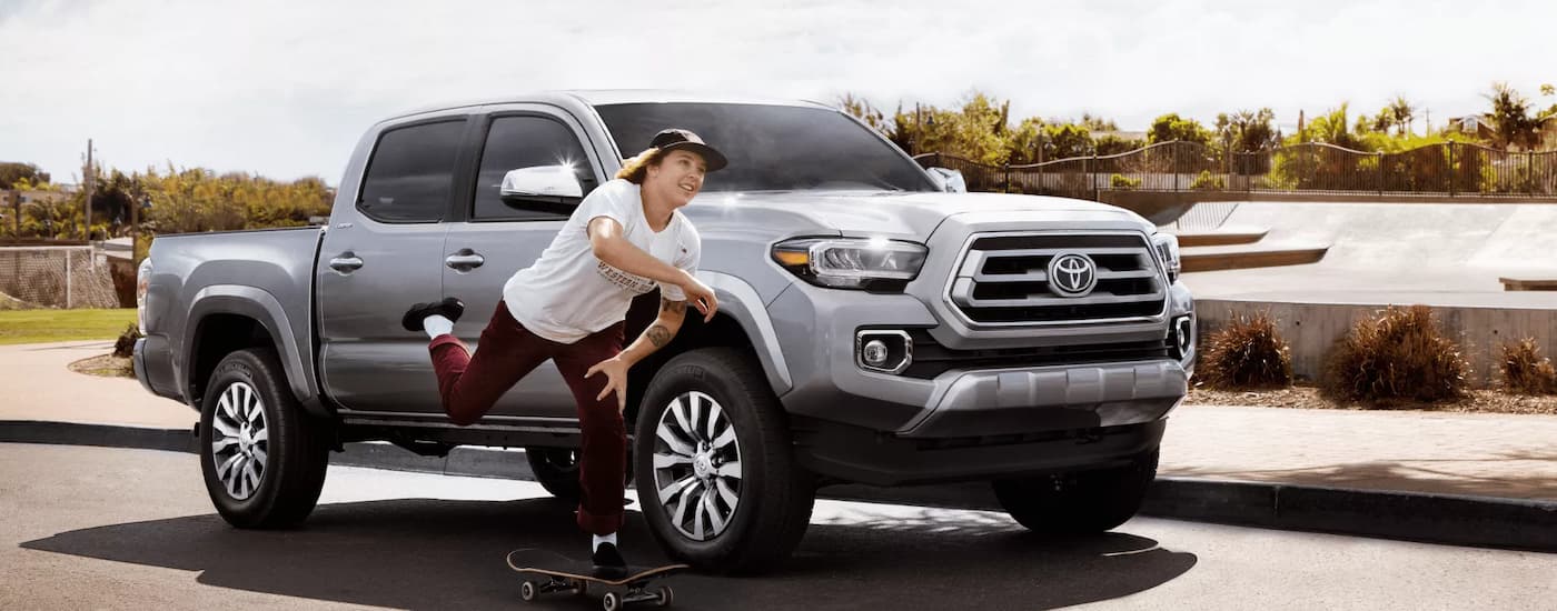 Person skateboarding next to a silver 2022 Toyota Tacoma