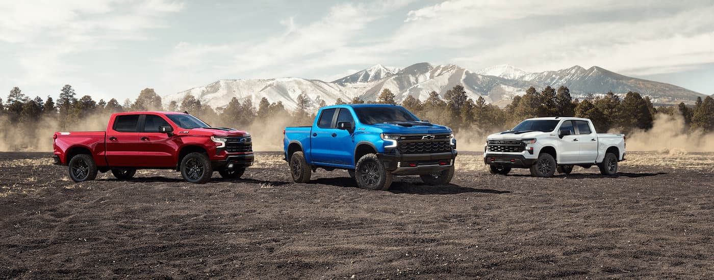 Three 2025 Chevy Silverado 1500s parked in a dirt lot
