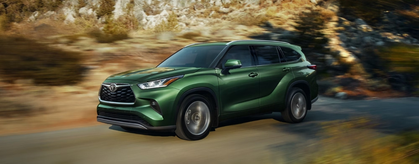 A green 2025 Toyota Highlander from the side.
