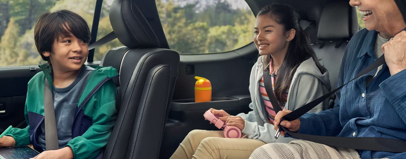 A family test driving a 2025 Toyota Highlander for sale near Canyon Lake