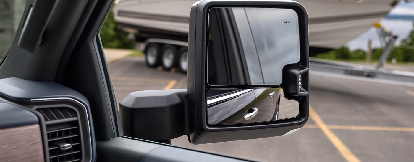 Side mirror of a 2025 Chevy Silverado 2500 HD next to a boat