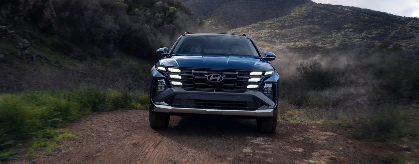 A blue 2025 Hyundai Tucson Limited driving on a trail.