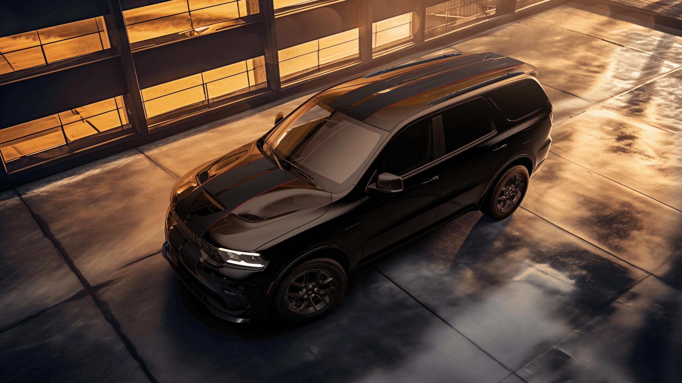 2026 Dodge Durango SUV exterior in glossy black, captured from above at sunset highlighting bold hood lines.