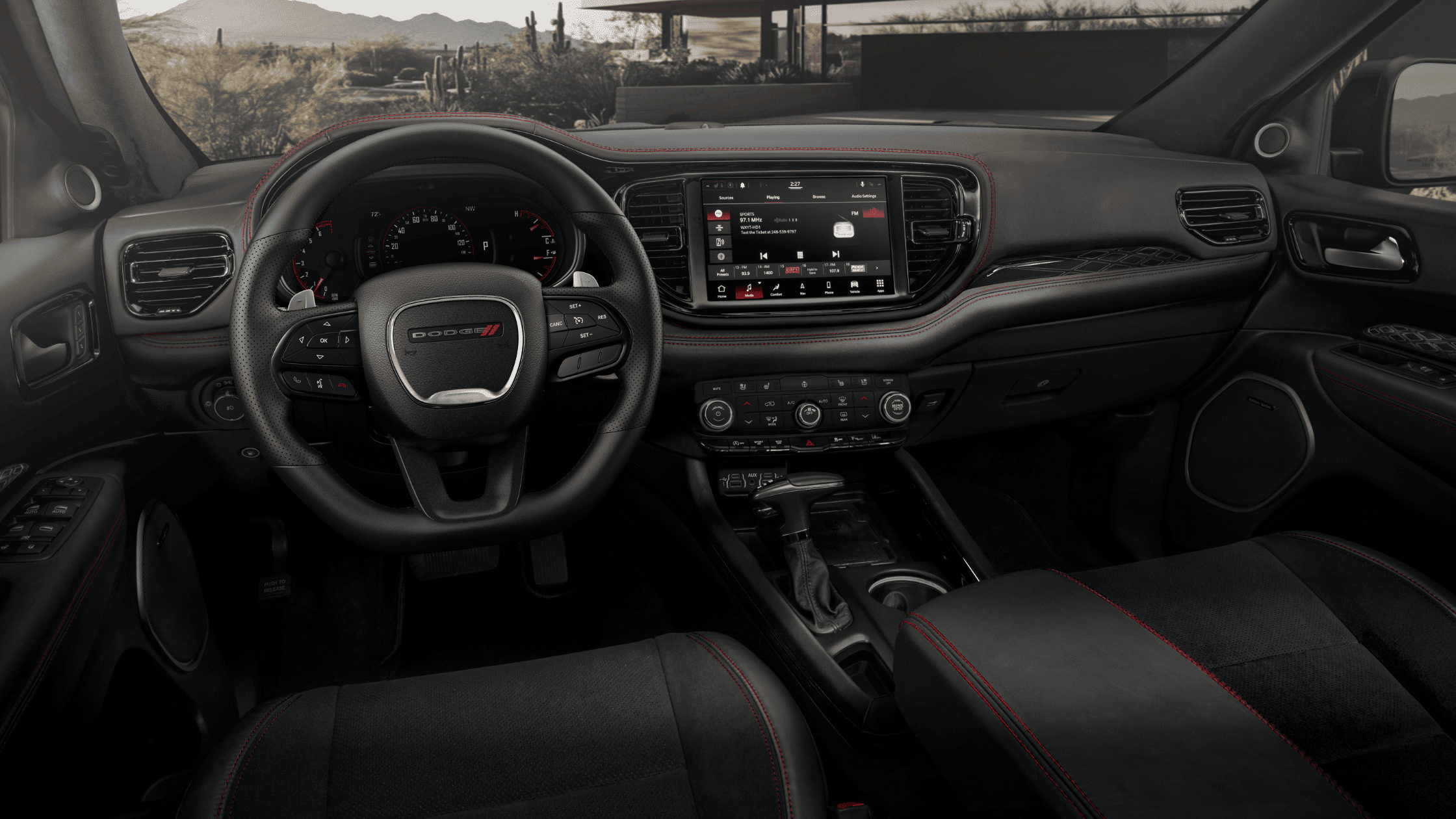 2026 Dodge Durango interior showing leather steering wheel, touchscreen display, and red-stitched dashboard