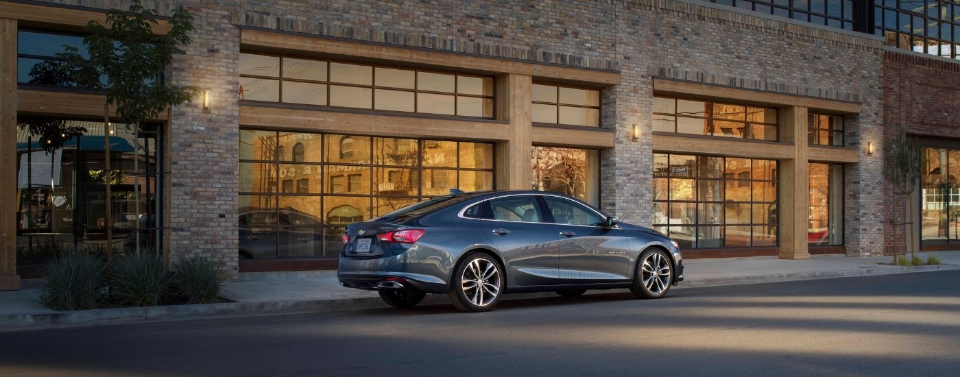 A grey 2021 used Chevy Malibu for sale from the side.