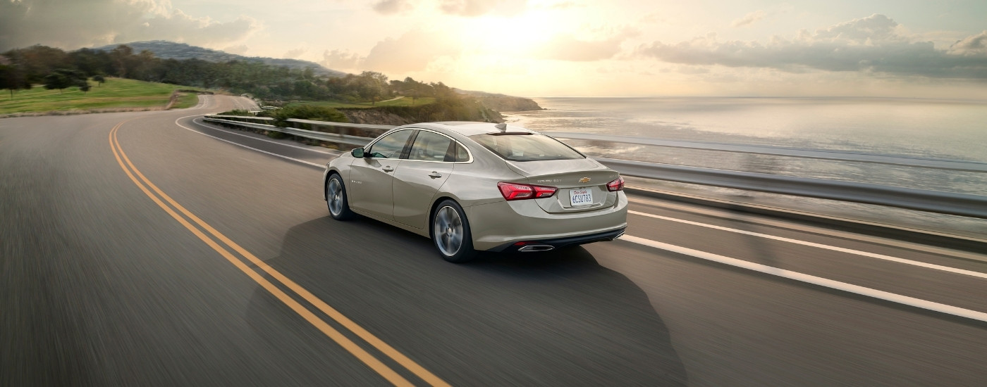 A tan 2024 used Chevy Malibu for sale from the rear at an angle.
