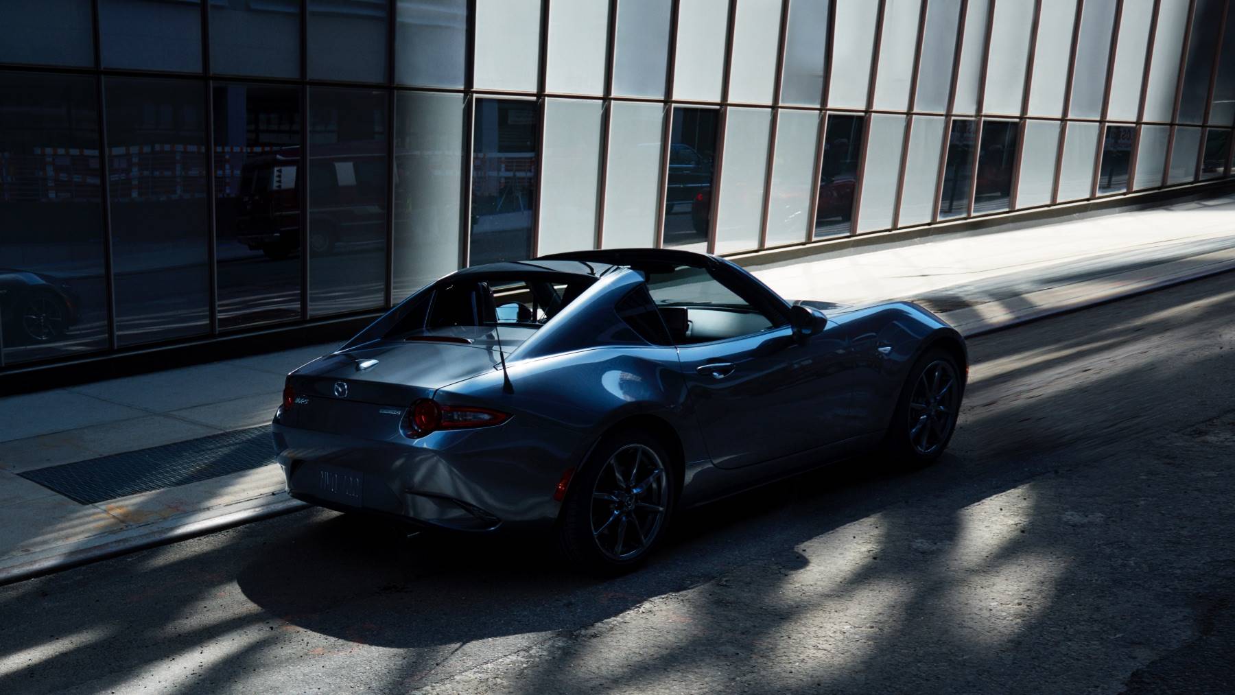blue mazda miata on the road