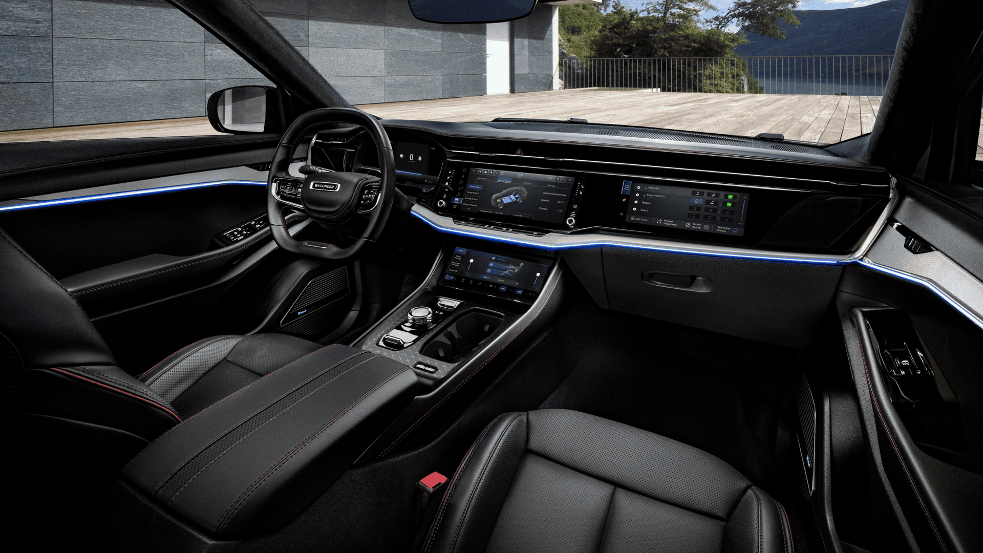 Driver&rsquo;s seat view of the 2025 Wagoneer S interior with ambient blue lighting and widescreen displays.