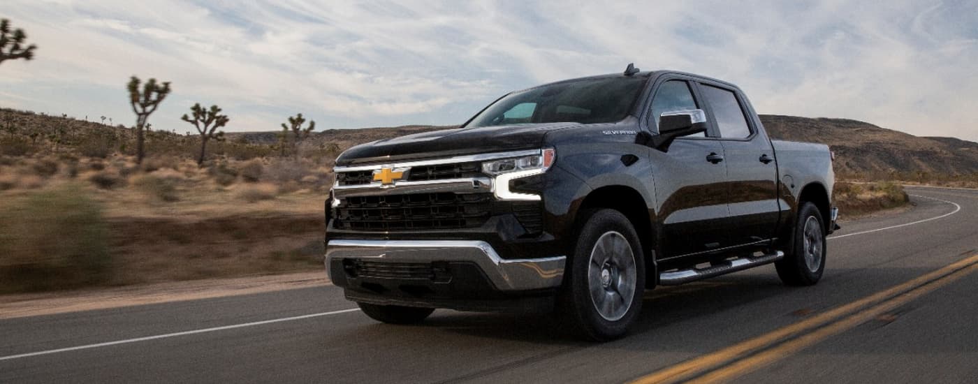Black 2022 Chevy Silverado 1500 driving on a winding desert road