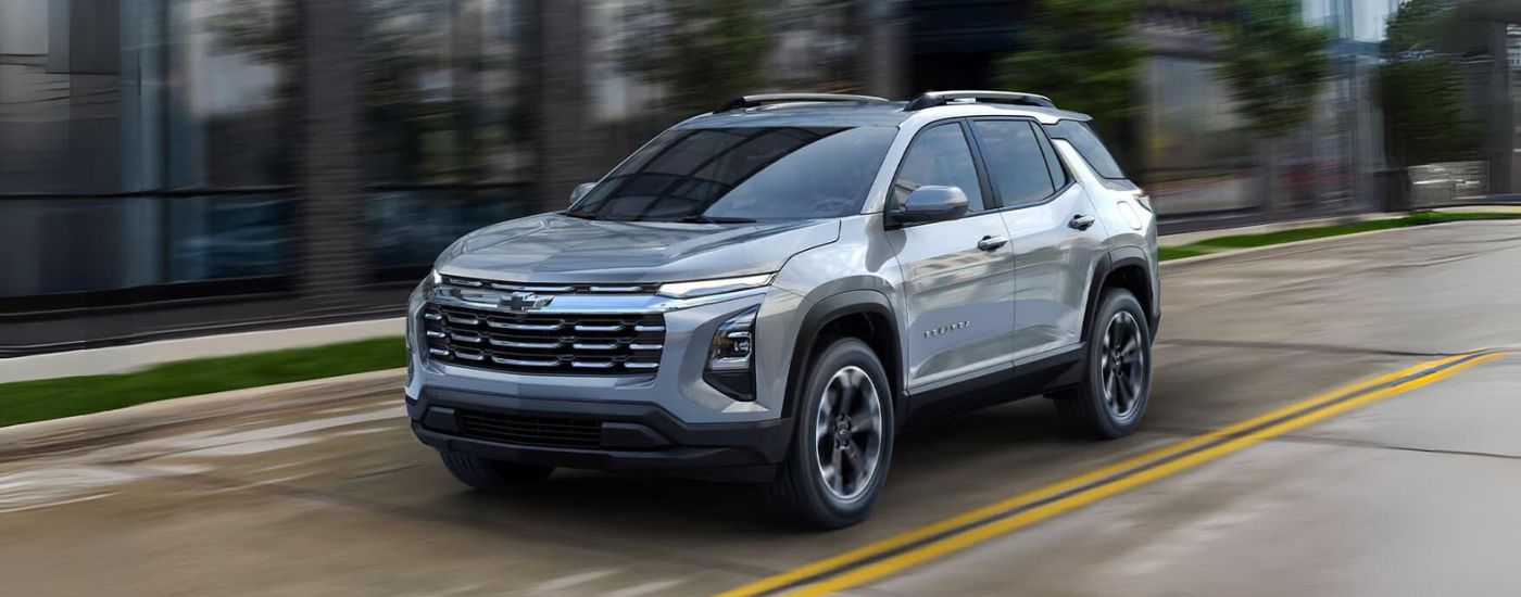 A silver 2025 Chevy Equinox driving on a city street