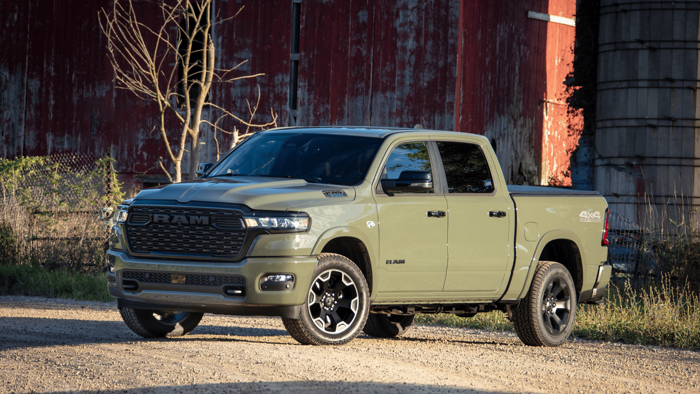 2026 Ram 1500 exterior in olive green parked near barn with rugged pickup design.