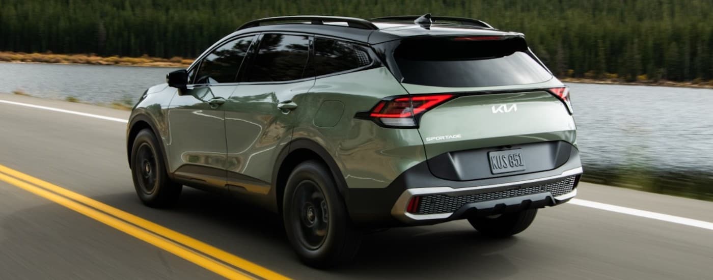 A green 2023 Kia Sportage from the rear at an angle.
