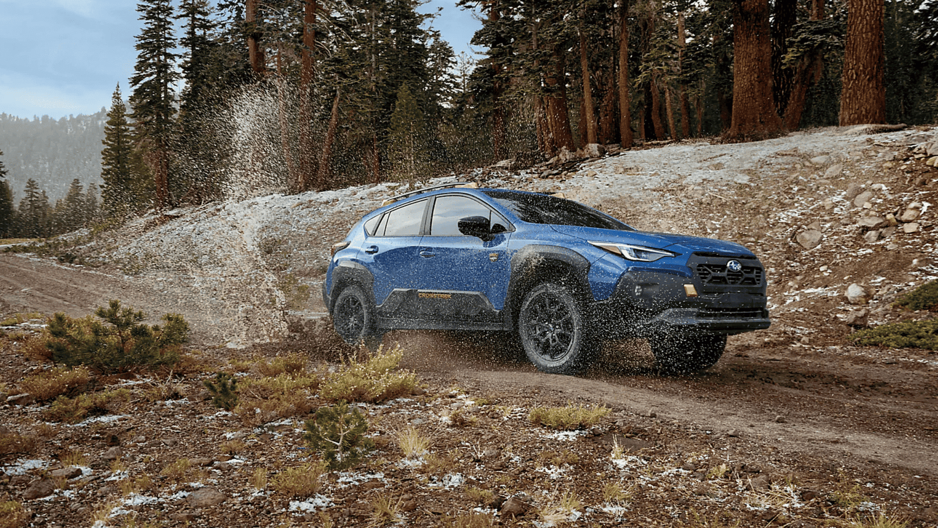2025 Subaru Crosstrek in Beckley WV splashing through a muddy trail, built for off-road adventures.