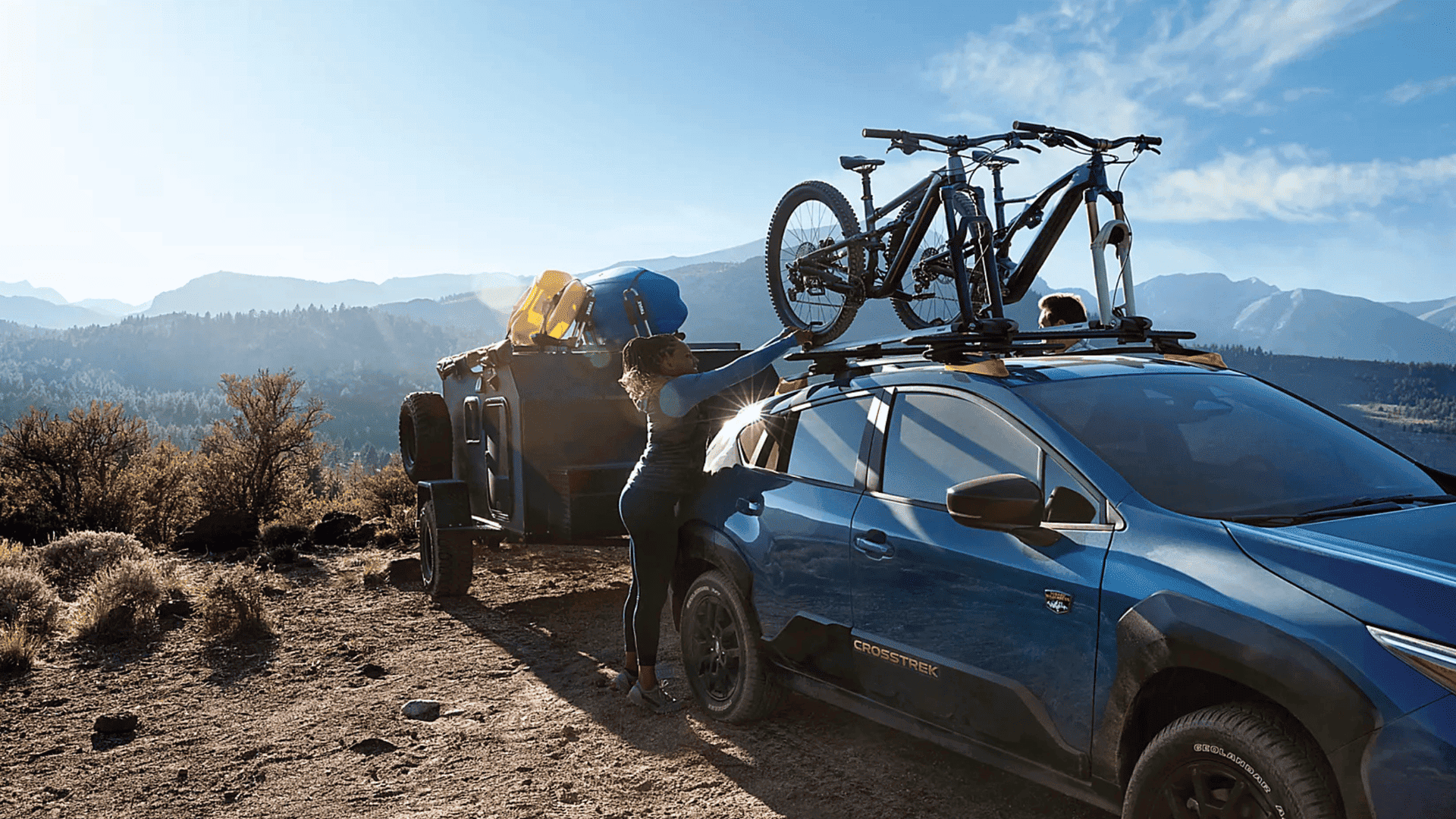 2025 Subaru Crosstrek with roof-mounted bikes and trailer, highlighting rugged design and utility.