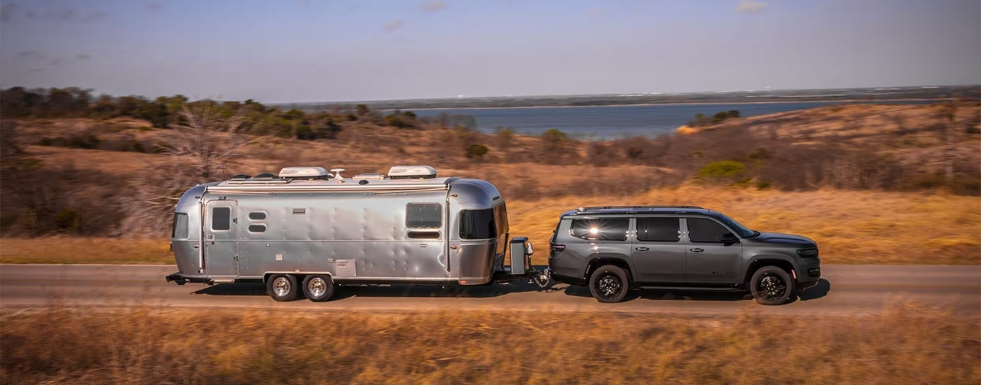 A grey 2025 Jeep Wagoneer from the side while towing.