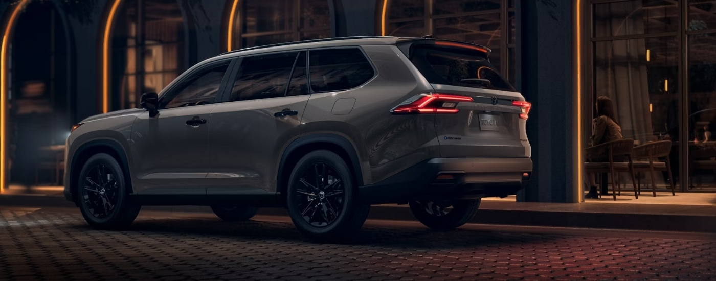 Grey 2025 Toyota Grand Highlander Hybrid Nightshade parked near a house