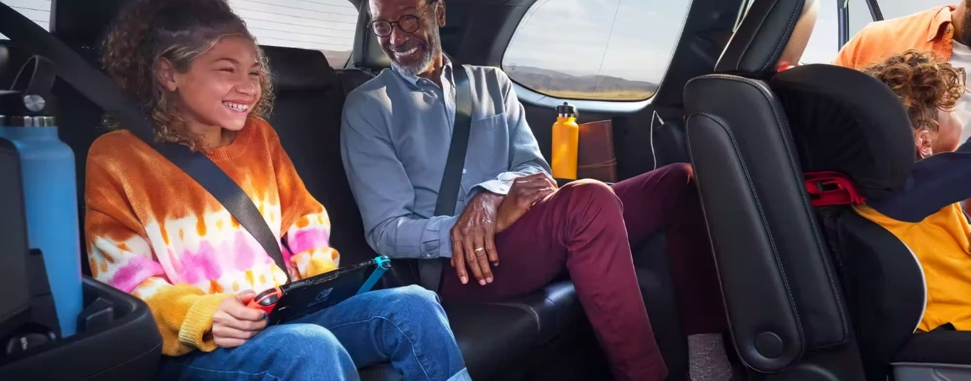Smiling people in the rear of a 2024 Toyota Grand Highlander Platinum MAX