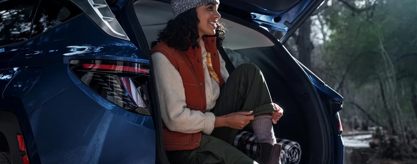 Woman sitting on the back of a 2026 Hyundai Tuscon