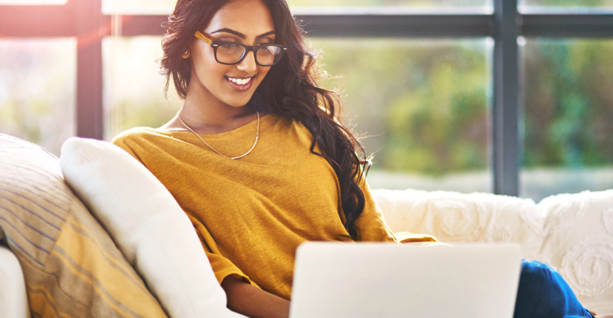 a woman looking at a laptop and smiling