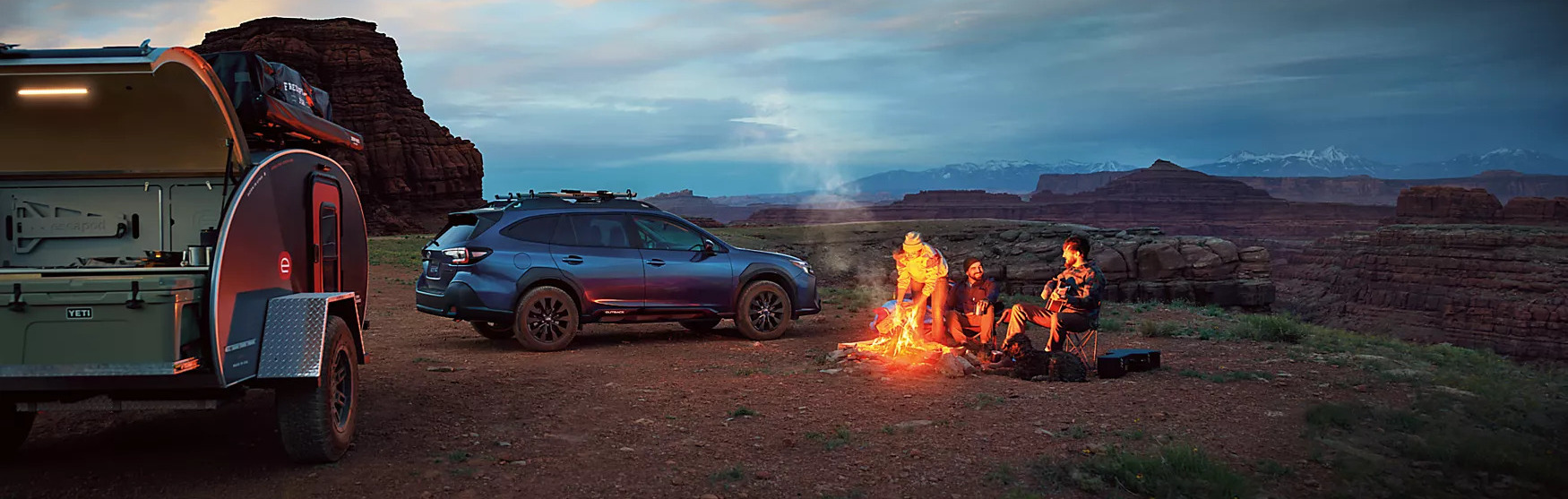 2025 subaru outback next to a tent and campfire at dusk in the dessert